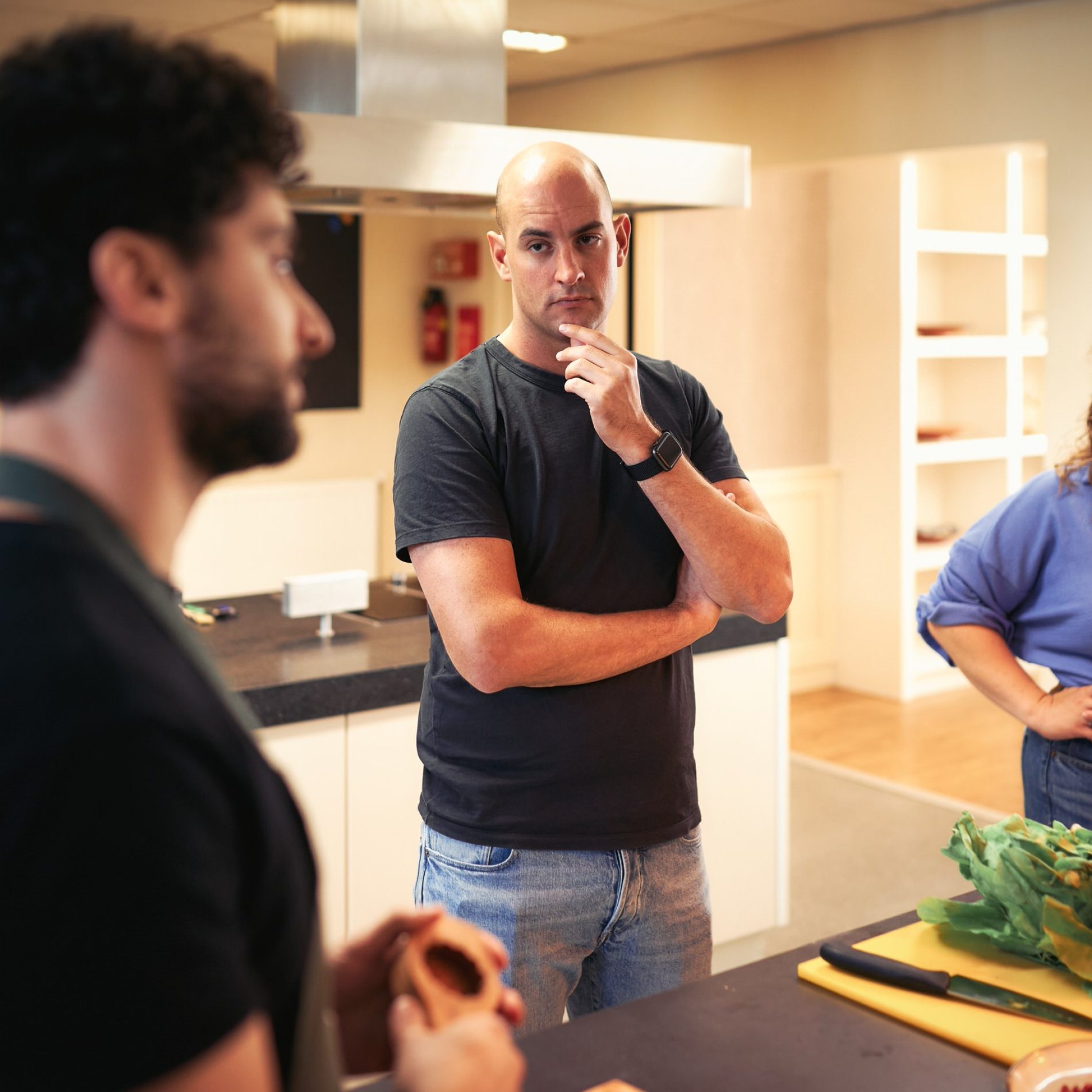 Vught Groep deelnemers: Een diverse groep mensen die luisteren naar de chef-kok, klaar om te beginnen met de kookworkshop.